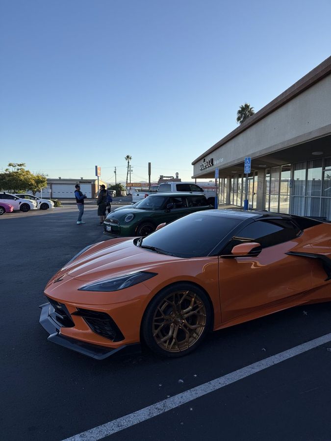 Orange Corvette parked in front of the Pet Zone showroom